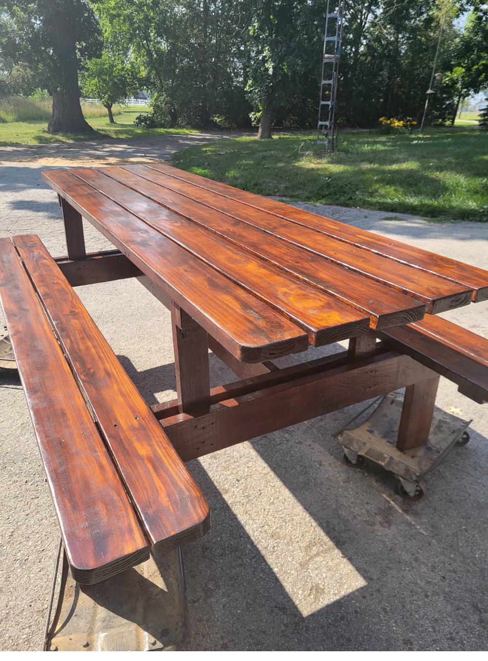 Dark-stained picnic table set with attached benches, thick lumber construction