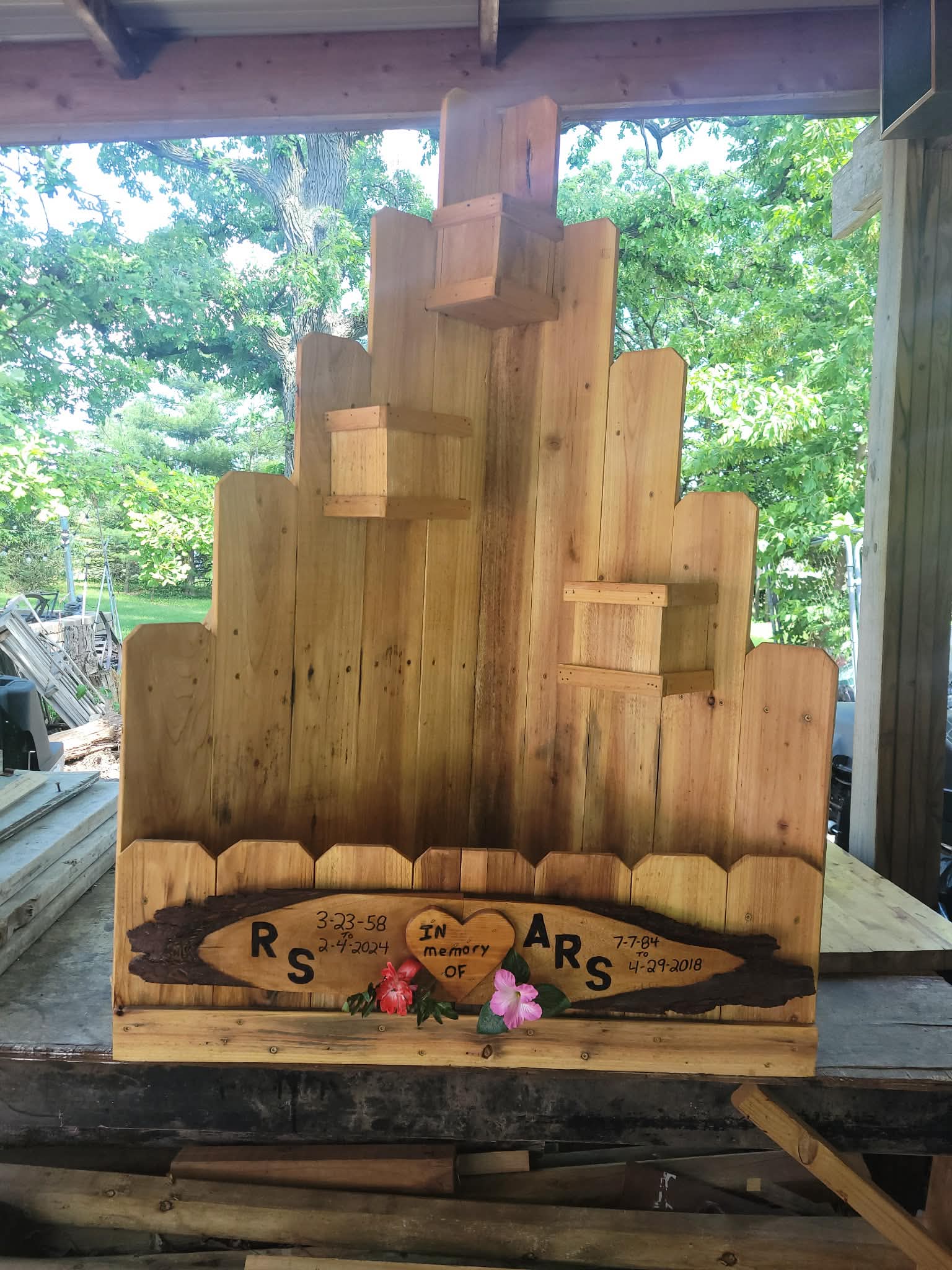 Custom handcrafted wooden memorial garden display with tiered structure and carved tribute plaque