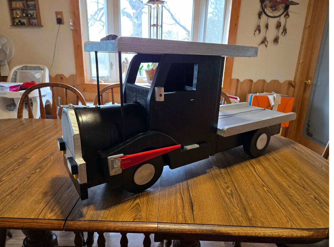 Custom wooden truck-shaped mailbox, painted black with details