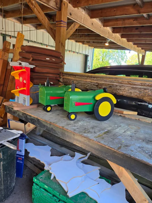 Custom wooden mailbox shaped like a green and yellow tractor