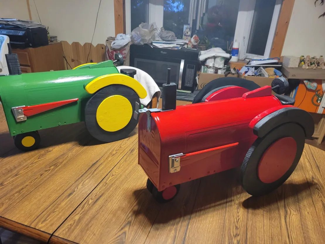 Green and red custom tractor mailboxes side by side