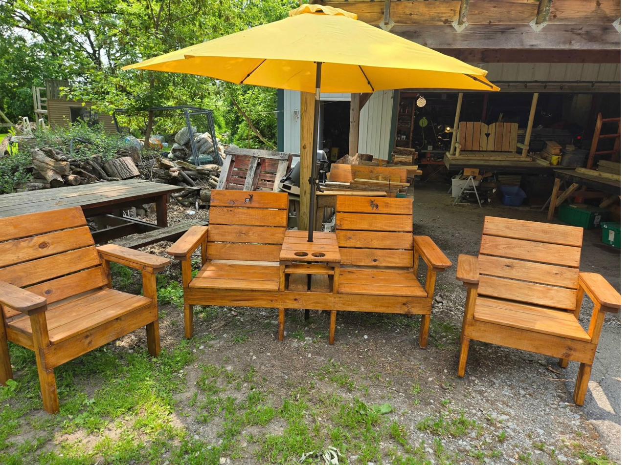 Handcrafted wooden patio furniture set with umbrella, love seat, and chairs with carved deer cutouts