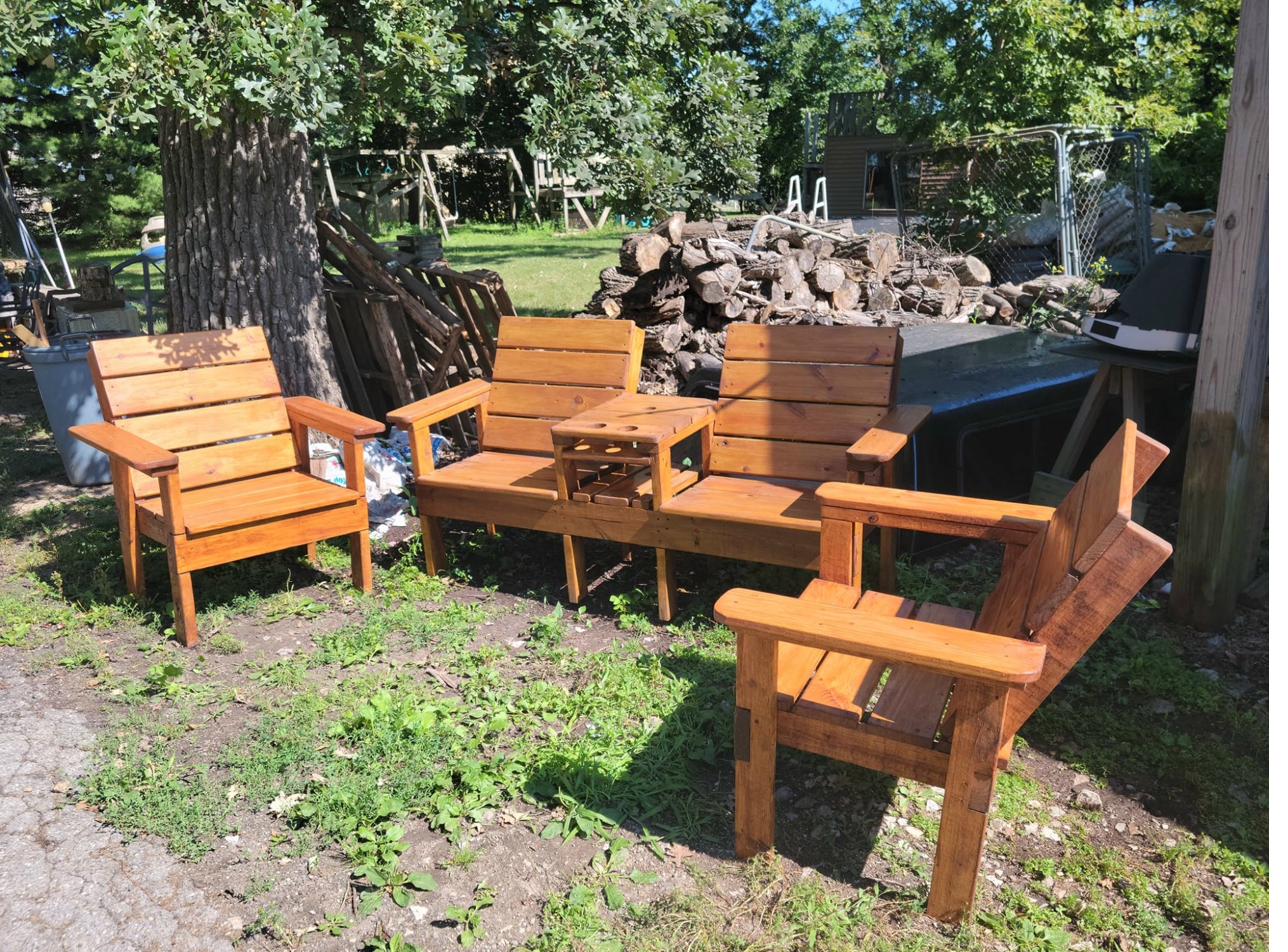 Stained wooden patio conversation set with 4 chairs and center table with cup holders