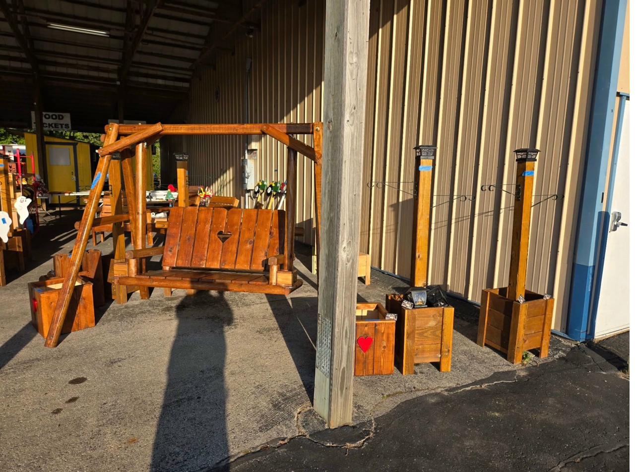 A-frame swing with heart cutout displayed at market with planters